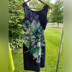 Dark blue dress, with Dahlia flower print. With cut-out back. Knee length.